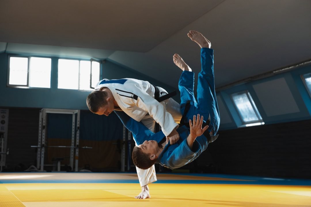 two young judo fighters in kimono training martial arts in the gym with expression in action and.jpg